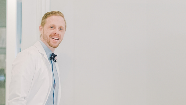 Doctor Holz smiling in a bow tie and white lab coat