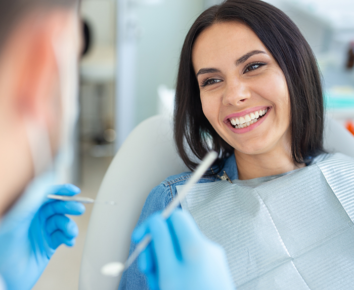 Woman grinning at her dentist during a preventive dentistry checkup