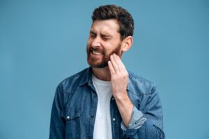 Man experiencing pain on one side of his jaw