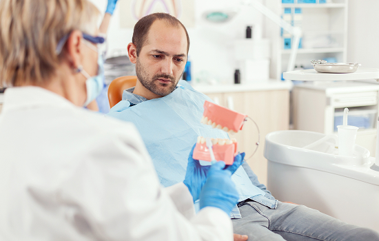 Illustration of a dental scaler clearing tartar buildup from the teeth